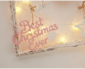 Detail of pink Christmas wooden ornaments with warm LED lights and Best Christmas Ever sign