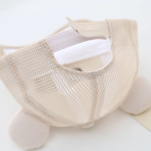 Close-up of breathable mesh fabric and adjustable velcro strap on cream baby sun hat