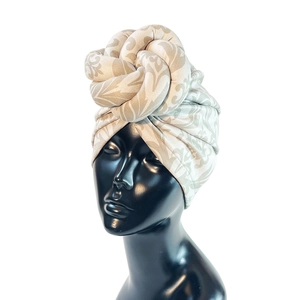 Detail of beige faux suede headwrap featuring retro floral prints and twisted knot design