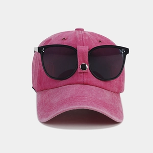 Close-up of pink pilot baseball cap featuring integrated black oversized sunglasses