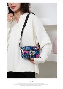 Detail of floral printed nylon crossbody bag with adjustable strap and star logo