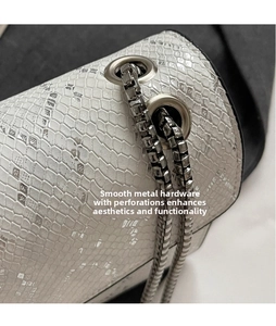 Close-up of cream snakeskin texture and silver chain strap on fashion crossbody bag