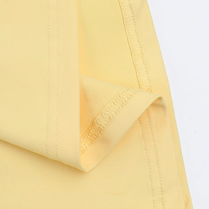 Détail de la couture à double aiguille et finition de l'ourlet sur la robe maxi jaune