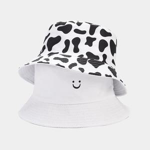 Detail of reversible fisherman hat showing cow print pattern and smiley face embroidery