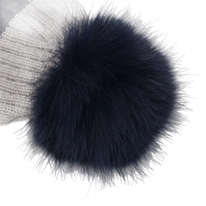Grey striped knit hat with a large navy blue pompom and warm ribbed texture
