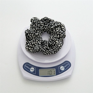 Classic leopard print scrunchie hair tie weighing approximately 10.1g on white scale