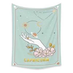 Detail of Capricorn zodiac tapestry featuring mint green background and golden sun motifs