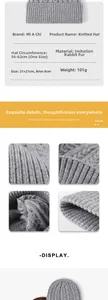 Detail of grey cable knit beanie showing 56-62cm size, folded brim and soft texture