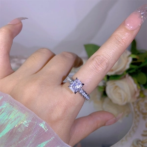 Detail shot of a luxury rectangular zircon ring with side stones on a model's finger