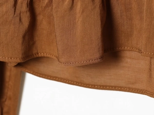 Detailed close-up showing the brown fabric texture and precise stitching on the hemline