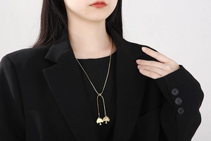 Collier chic en or avec pendentif arbre de vie sur une chaîne serpent et blazer noir