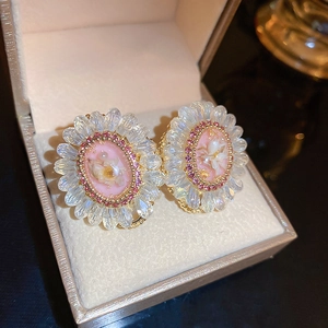 Detail view of flower earrings featuring pink dried flowers and sparkling crystals