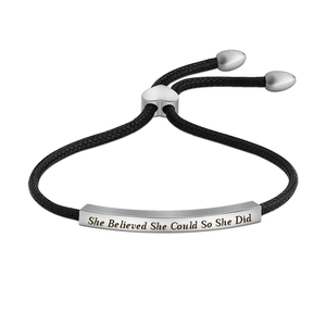 Close-up of engraved inspirational message on silver bar with black woven rope bracelet