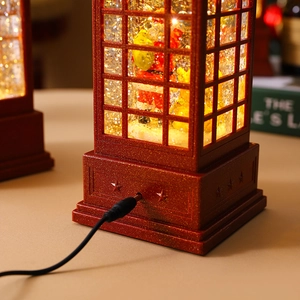 Close-up of the DC power port on a vintage red Santa Claus phone booth snow globe lamp