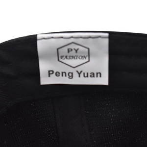 Macro view of interior fabric detail and woven brand label on a black baseball cap
