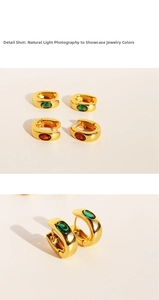 Macro shot of U-shaped gold earrings set with oval emerald and ruby zircons