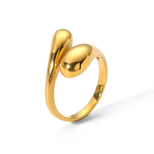 Close-up of polished gold teardrop crossover ring with glossy metallic finish