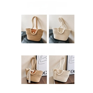 Detail view of woven tote bags in khaki and white with leather flaps and pearl accents