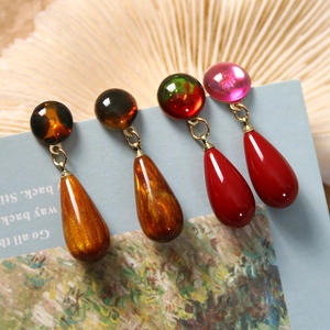 Detailed macro view of vintage colorful resin teardrop earrings in amber and red hues