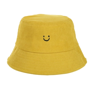 Détail du chapeau bob en velours côtelé jaune avec texture côtelée et sourire brodé