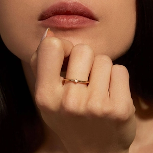 Minimalist 925 silver ring with micro-set diamond on elegant gold band worn by model