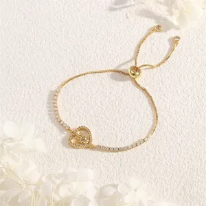 Detail of adjustable gold-plated heart bracelet with sparkling zircon stones and hand charm