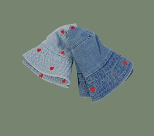 Detailed view of red heart embroidery on light and dark blue denim bucket hats
