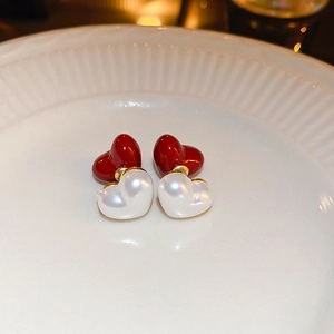 Vue détaillée des boucles d'oreilles perles en cœur avec accents dorés et rouges