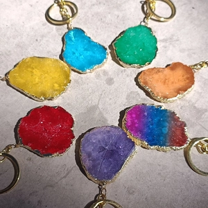Macro view of colorful irregular natural stone keychains with golden plated edges