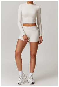 Détail d'un haut court blanc à manches longues et d'un short de yoga à taille haute