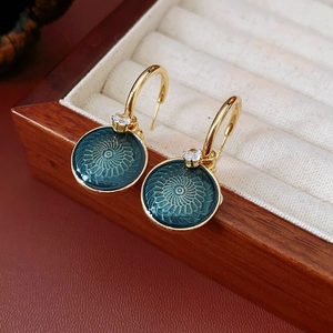 Detail of vintage flower earrings with green spiral texture and zircon in wooden box