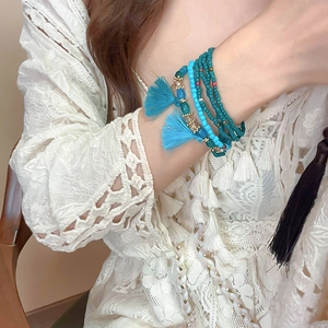Close-up of Bohemian layered beaded bracelet with blue tassels and turquoise beads