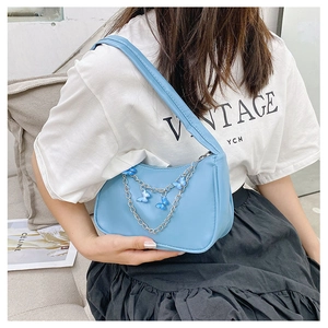 Close-up of light blue PU leather underarm bag with decorative butterfly metal chain