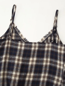 Detail of V-neck plaid dress featuring raw fringe edges and adjustable spaghetti straps