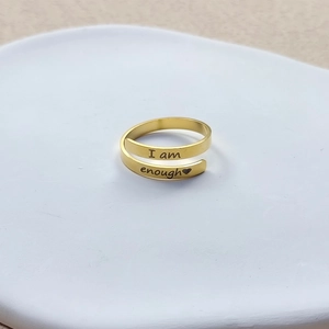 Macro shot of gold stainless steel ring with I am enough engraving and heart detail