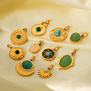 Detailed close-up of assorted gold titanium steel pendants with natural gemstones on silk
