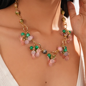 Close-up of vintage beaded necklace with green stones and pink translucent charms
