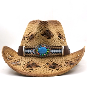 Détail d'un chapeau de cowboy en paille tressée avec perles ethniques et turquoise bleue