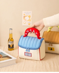 Detail of cute quilted cosmetic bag with LUCKY embroidery handle and puppy patch