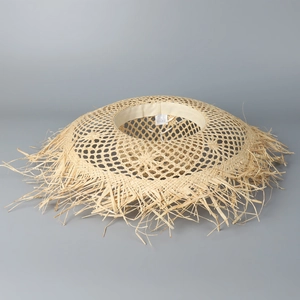 Close-up of wide-brimmed raffia straw hat with frayed edges and inner sweatband detail