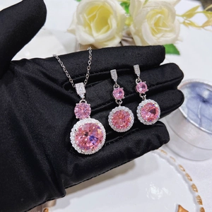 Detail shot of sparkling pink zircon necklace and earrings set on black velvet background