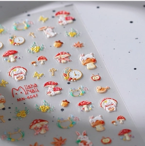 Macro shot of 3D embossed nail stickers featuring autumn rabbits and maple leaf patterns