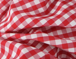 Macro du tissu à carreaux rouge et blanc avec tissage uni lisse et drapé souple du vêtement