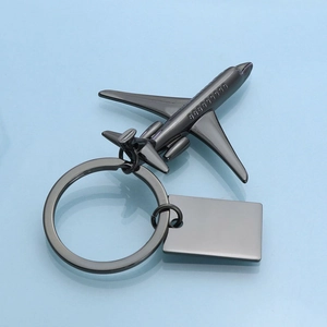 Gunmetal J-20 fighter jet keychain with metal tag on a minimal blue background