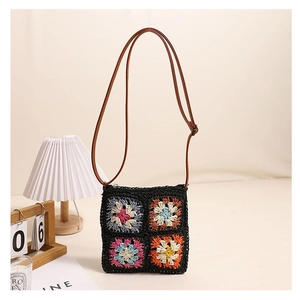 Detail of square black crochet straw bag featuring four colorful floral patterns