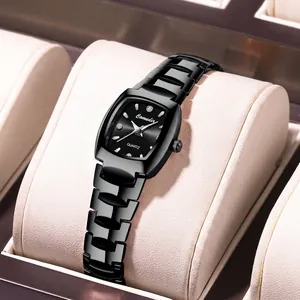 Macro shot of a black tonneau quartz watch with rhinestone markers on a leather cushion
