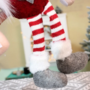 Detailed macro view of striped knit legs and soft faux fur boots on Christmas curtain buckle