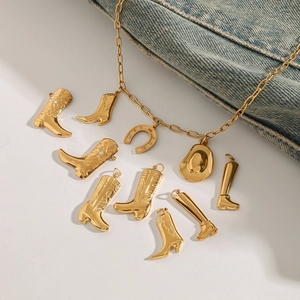 Golden titanium steel necklace with cowboy boot and hat pendants on denim background