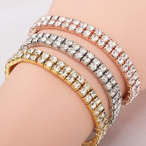 Three rows of tennis bracelets in gold, silver, and rose gold with clear crystals