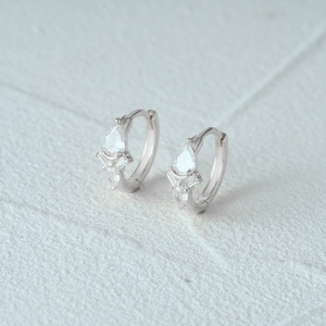 Macro detail of silver geometric earrings with pear and rectangular cut zircons